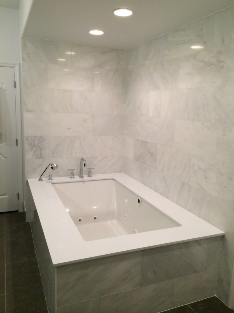 Bathroom Moda White Marble walls and Super White quartz tub deck